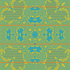A woollen blanket with a geometric pattern featuring hearts and floral motifs in peacock blue, gold, and orange colors on a checkered background.